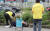 서울시 폭염 특별대책반 대원이 8일 서울역 광장에서 노숙인의 건강상태를 살피고 있다. 대책반은 노숙인들에게 생수와 식염 포도당을 나눠 준다. [우상조 기자]