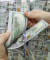 한 은행원이 100달러 짜리 미국 지폐를 세고 있다. 달러화는 올해 들어 9% 하락했다. [연합뉴스]