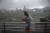 한 홍콩 여성이 23일 태풍 하토가 몰려오고있는 빅토리아 항구에서 휴대폰을 만지고 있다.[AFP=연합뉴스]