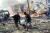 14일 폭탄 테러 직후 소말리아 수도 모가디슈에서 두 남성이 부상자를 옮기고 있다.[AP=연합뉴스]