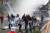 온두라스 대학생들이 지난 8월 2일(현지시간) 수도 테구시칼파에서 반정부 시위를 벌이다 경찰이 쏜 최루탄을 피해 달아나고 있다.[AFP=연합뉴스] 