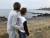 제주시 한경면 판포리 해안을 찾은 관광객들이 갯바위를 뒤덮은 회색물질을 손으로 가리키고 있다. 최충일 기자