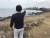 제주시 한경면 판포리 해안을 찾은 관광객들이 갯바위를 뒤덮은 회색물질을 손으로 가리키고 있다. 최충일 기자