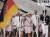 1964 도쿄올림픽 개회식에서 오륜마크를 새긴 삼색기를 앞세워 입장하는 독일 선수단 [사진 IOC 홈페이지]