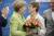 앙겔라 메르켈 총리가 지난해 3월 자를란트주 선거를 승리로 이끈 안네그레트 크람프-카렌바우어 총리에게 꽃다발을 주고 있따. [EPA=연합뉴스]