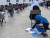 아마디가 아프가니스탄 닐리의 한 고사장에서 아이를 안은 채 대학 입학 시험을 치르는 모습. [사진 나시르 후스라우]