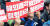 지난 24일 광주 금남로에서 열린 ‘금호타이어 해외 매각 철회 1차 범시도민대회’에 참가한 한 금호타이어 노조 조합원이 ‘해외 매각 철회하라’는 피켓을 들고 있다. [뉴스1]