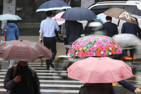 전국 대부분 지역에 비가 내린 23일 오전 화려한 우산을 쓴 시민들이 서울 조계사 인근을 지나고 있다. [연합뉴스]
