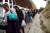 미국-멕시코 국경에 도착한 이민자 행렬이 29일(현지시간) 국경을 따라 걷고 있다. [로이터=연합뉴스] 