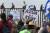 이민자 캐러밴 행렬에 참가한 사람들이 29일(현지시간) 미국-멕시코 국경에 올라가 시위를 벌이는 가운데 이를 지지하는 미국 쪽 시위대가 이들을 맞이하고 있다. [AFP=연합뉴스]  