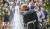 결혼식을 마친 영국 해리 왕자와 미국 할리우드 배우 메건 마클이 하객들의 스마트폰 카메라 세례를 받으며 키스를 하고 있다. [AP=연합뉴스]