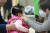 독감 증세로 병원 소아청소년과를 찾은 가족이 자녀에게 마스크를 착용시키고 있다. [연합뉴스]