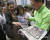 일본 요미우리 신문 직원이 12일 오전 일본 도쿄에서 북미 정상회담 소식이 담긴 호외를 시민들에게 나눠주고 있다. [AP=연합뉴스]