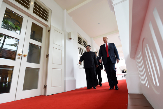 김정은 북한 국무위원장과 도널드 트럼프 미국 대통령이 12일 싱가포르 센토사섬 카펠라호텔에서 정상회담을 하기 위해 나란히 복도를 걸어가고 있다. [AFP=연합뉴스]