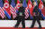 김정은 북한 국무위원장과 도널드 트럼프 미국 대통령이 12일 싱가포르 센토사 섬에서 공동서명한 문서를 들고 걸어 나오고 있다. [AP=연합뉴스]