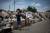 폭우 피해가 발생한 오카야마 현에서 11일(현지시간) 한 남성이 물에 잠겨 훼손된 물건을 폐기 용품을 모아놓은 공간에 버리고 있다. [AFP=연합뉴스]