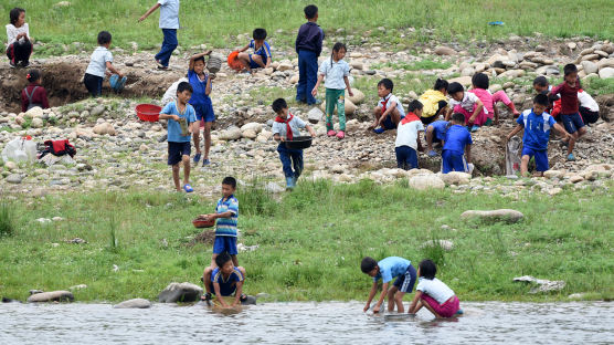 [서소문사진관]옷색깔 변화된 압록강의 북한 어린이들