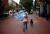 북 캘리포니아에서 온 메리 그레이스가 11일(현지시간) 백인 우월주의에 반대하는 피켓을 들고 버지니아 샬러츠빌 시내를 걸어가고 있다.[AFP=언합뉴스]