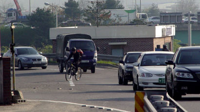 도로에 나간 자전거 ‘자동차와 곡예 대행진’
