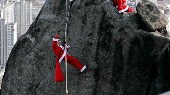 [사진] 선물 짊어지고 산 타는 산타