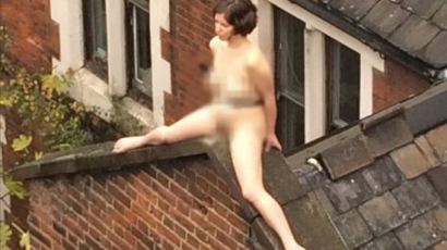 나체로 지붕 위에 올라가 앉아 있는 여성 '이유가?"