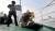목포 인근 해역에서 해군 3함대사령부 주관으로 실시된 해군ㆍ해경 합동 해양차단작전 훈련에서 해경 특공대(왼쪽)와 해군 특임대(오른쪽)가 함께 의심선박 선원을 제압하고 있다.  [사진 해군]