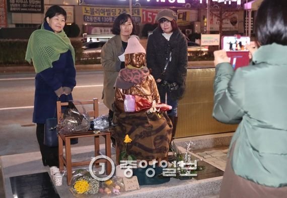 6일 오후 일본 정부가 부산 일본영사관 앞에 설치된 위안부 소녀상과 관련해 전방위 압박에 나선 가운데 시민들이 부산 영사관 앞에 설치된 소녀상에서 기념촬영을 하고 있다. 송봉근 기자 