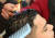 오드완이 손님의 머리카락에 라이터로 불을 붙이고 있다. [로이터=뉴스1]