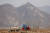 지난 2일 북한 신의주 압록강변에서 주민들이 트랙터에 흙을 옮겨싣고 있다.뒤로 중국 만리장성의 출발이라는 단둥의 호산장성이 보인다.[로이터=뉴스1]