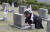 18일 서울 4.19 묘역에서 한 참배객이 오빠 묘소에 자신의 자서전을 놓으며 눈물 흘리고 있다. 임현동 기자 