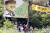 故노무현 전 대통령 서거 7주기 추도식이 엄수된 23일 오후 경남 김해시 진영읍 봉하마을에서 시민들이 나무 그늘에 앉아 추도식을 보고 있다. [사진공동취재단]
