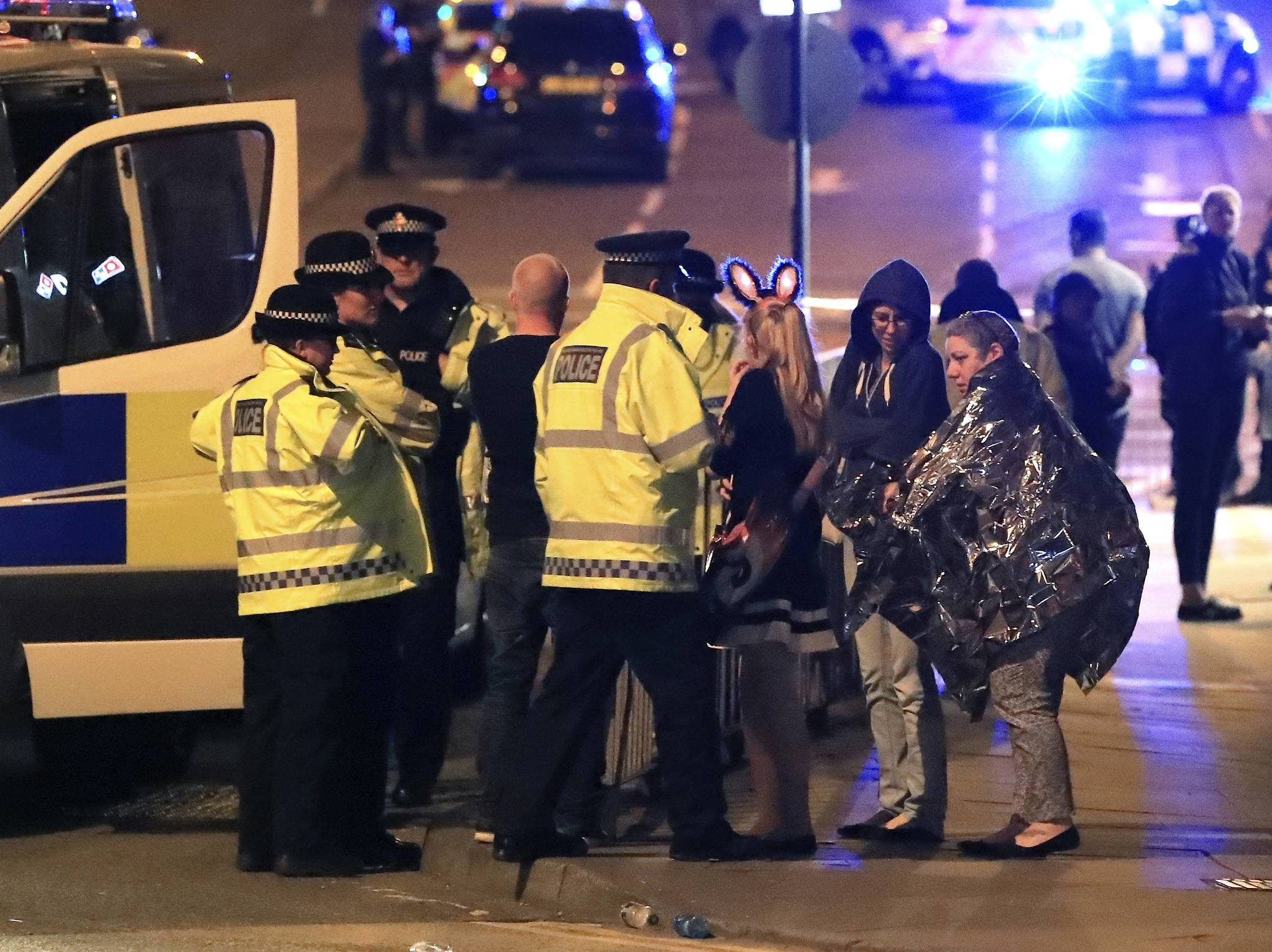 22일(현지시간) 테러로 추정되는 폭발 사건이 발생한 영국 맨체스터의 맨체스터 아레나 앞에서 경찰이 피해자들과 대화하고 있다. [AP=연합뉴스]