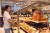 지난 23일 현대백화점 무역센터점에 세계 최초로 문을 연 이즈니 베이커리에서 고객이 빵을 고르고 있다. [사진 현대백화점]