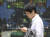 28일 일본 도쿄의 증권가 증시 전광판 앞으로 한 회사원이 지나가고 있다. [도쿄 AP=연합뉴스]