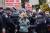 19일 세제 개혁법안 표결을 앞두고 뉴욕증권거래소(NYSE) 앞 반대 시위에 참가한 한 시민이 경찰에 연행되고 있다. [AP]