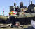 러시아 탱크 승무원들이 9일(현지시간) 승무원의 날 행사에서 받은 꽃다발을 탱크에 싣고 기동하고 있다. [타스=연합뉴스]