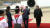김여정 북한 노동당 제1부부장이 18일 평양 순안공항에서 문재인 대통령이 화동에게 받은 꽃다발을 챙기고 있다. [화면 캡쳐]