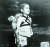 1945년 8월 일본 나가사키 원폭투하 직후 숨진 동생을 업은 소년이 화장터 앞에서 장례 순서를 기다리며 굳은 표정으로 서있다. [연합뉴스] 