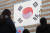 제100주년 3.1절을 사흘 앞둔 26일 서울 종로구 광화문 교보생명 빌딩 외벽에 대형 태극기가 부착되고 있다. [뉴스1]