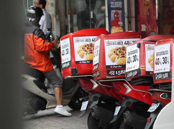 치솟는 배달용 오토바이 보험료로 인해 자영업자의 부담이 가중되고 있다. 서울 마포 한 피자집 앞에 배달 오토바가 세워져 있다. [중앙포토]