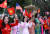 베트남 전통의상을 입은 시민들이 지난 27일(현지시간) 정부 빌딩 앞에서 트럼프 대통령을 향해 국기를 흔들고 있다. [EPA=연합뉴스]
