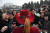 취재진이 붉은 모자를 쓴 소수민족 대표를 상대로 취재경쟁을 벌이고 있다.[AFP=연합뉴스]