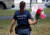 한 경찰이 17일(현지시간) 주민들이 건넨 추모 꽃다발을 들고 있다. [로이터=연합뉴스]