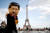 콧수염을 붙인 시진핑 중국 국가주석의 탈을 쓴 한 사람이 25일(현지시간) 프랑스 파리 에펠탑 앞에 서 있다. [로이터=연합뉴스]