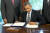 왼손으로 서명하는 오바마 전 미국 대통령. [UPI=연합뉴스]