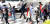 9일 오후 경남 창원시 마산회원구 합성동에서 신호등을 걷는 시민들이 양산이나 종이로 햇볕을 가리고 있다 [연합뉴스]