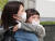 서울 광화문네거리에서 어린이가 엄마 품에 안겨 마스크를 쓰고 있다. [뉴스1]