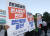 지난 22일 오후 울산시청 앞에서 열린 &#39;한국조선해양 본사 울산 존치 범시민촉구대회&#39;에서 시민이 현대중공업 본사 이전과 분할에 반대하는 팻말을 들고 서 있다. [연합뉴스]
