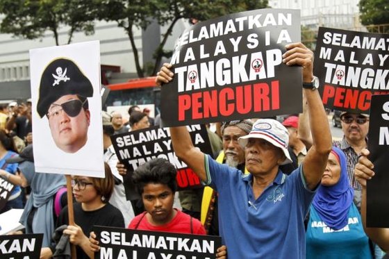지난해 4월 말레이시아에서 시민들이 ‘말레이시아를 구하라, 도둑(조 로우)을 체포하라’란 플래카드를 들고 시위하고 있다. [AP=연합뉴스]