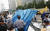 우리공화당 당원들이 28일 오전 광화문 광장에 설치된 천막을 파이낸스빌딩 근처로 옮기기 위해 철거하고 있다. [연합뉴스] 